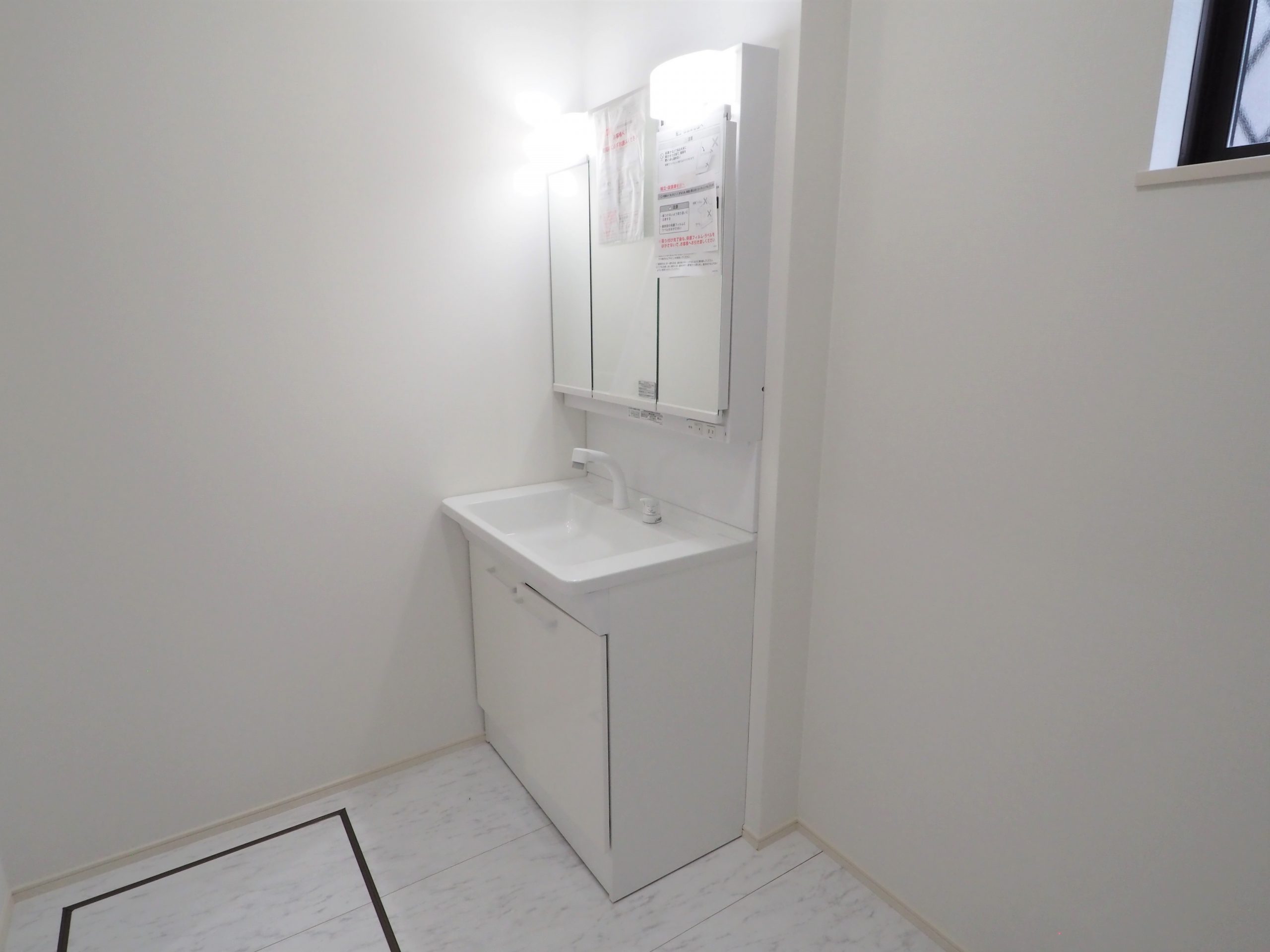 坂戸市にっさい新築店舗カットハウストシの洗面化粧台画像です。白い洗面化粧台が清潔感を感じます。