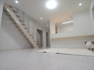 坂戸市にっさい新築戸建て住宅のリビングルーム画像。白のクロスと白のフローリングで開放感のある空間を演出しています。２階へつながる階段はスケルトン階段です。