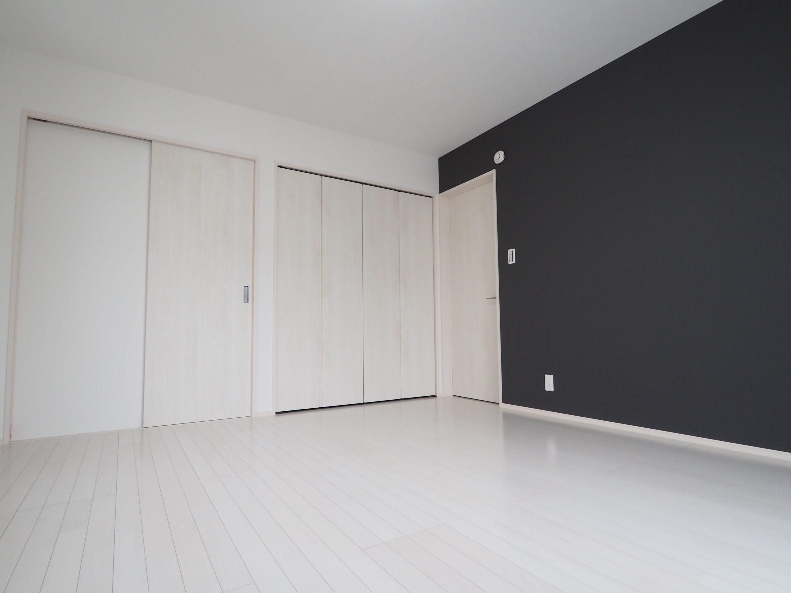 坂戸市にっさい新築戸建住宅の２階洋室画像。白のフローリング白のドアで白を基調にしました。アクセントクロスで紺を使いスタイリッシュで洗練された印象です。