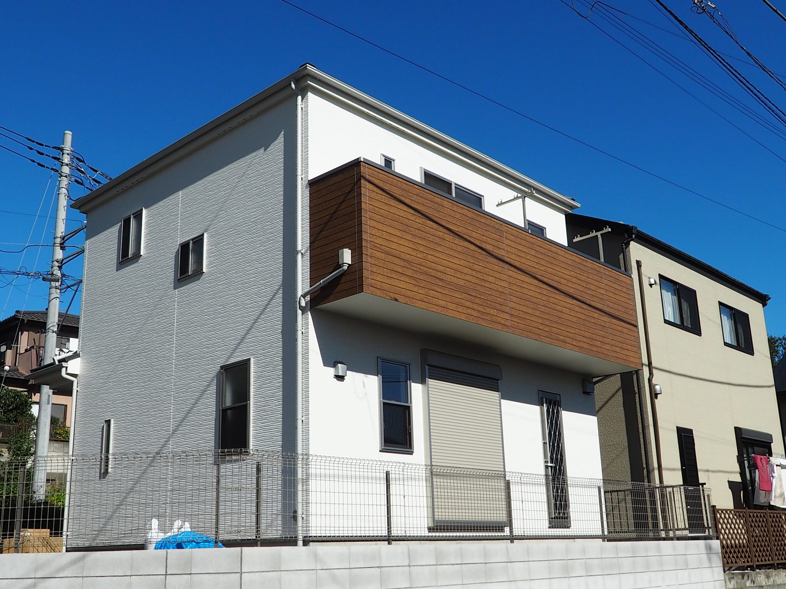 所沢上安松新築戸建て住宅外観画像。白を基調とした外壁にバルコニー部分の外観は木目調にしてアクセントをもたせました。
