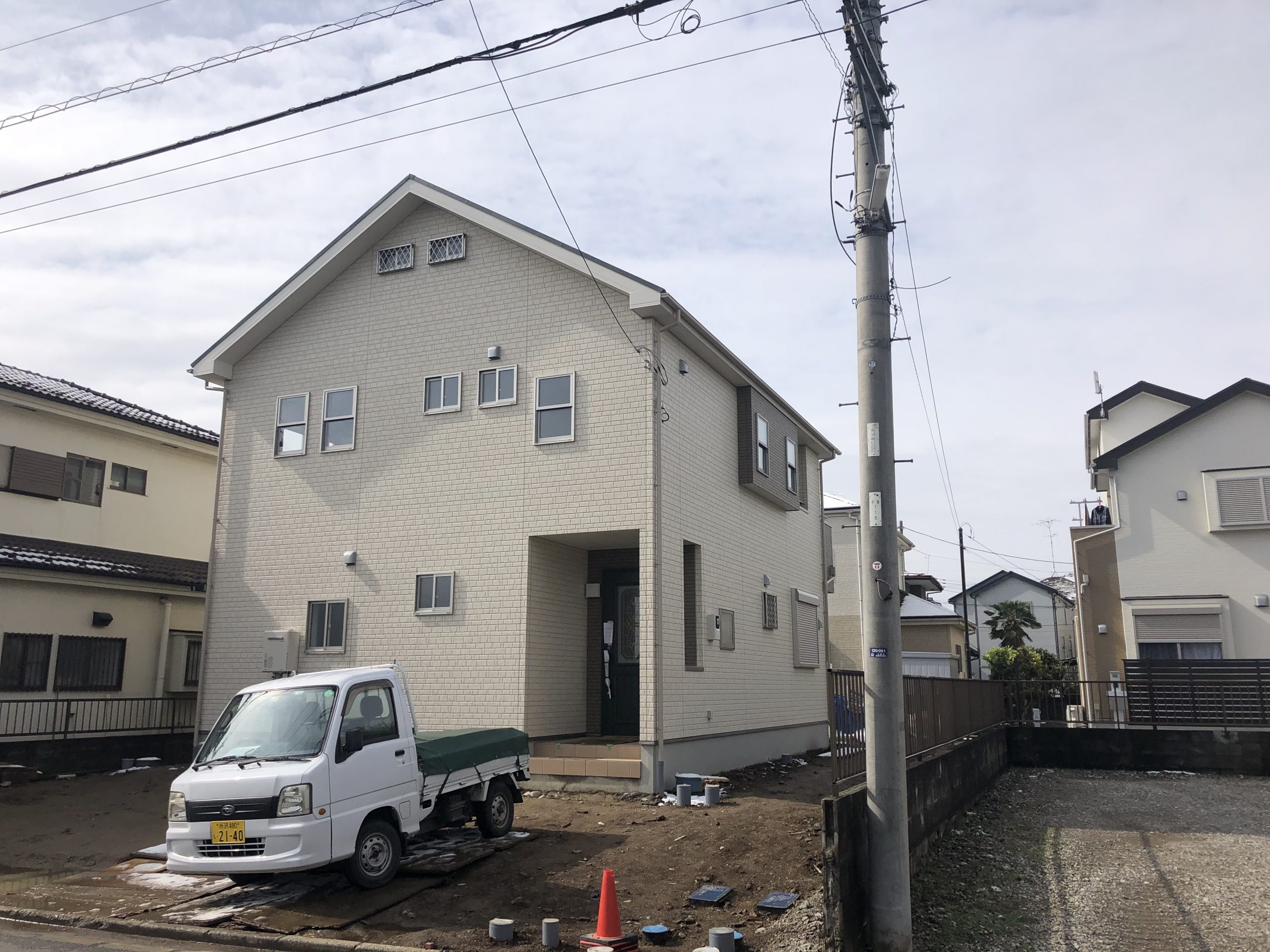 上尾市新築戸建て住宅外観、白い外壁にグリーンカラーの玄関ドアが映えています。
