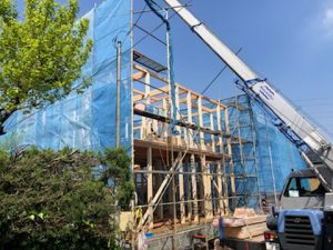 日高市二区画新築工事B号棟の上棟、重機で木材を運んでいる画像です