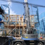 日高市二区画新築工事B号棟の上棟式、重機で材木を運んでいる画像です