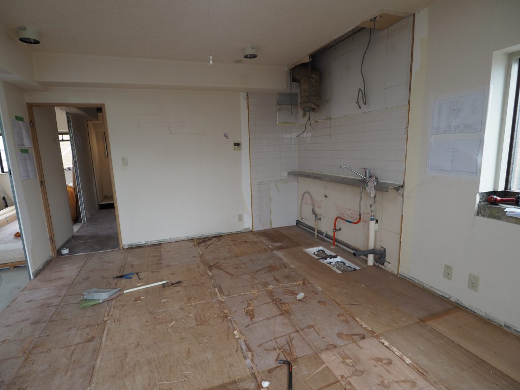 プレミール和光マンションリフォーム現場、リビングルームのキッチンを取外して、床を剝がしたのが写っています