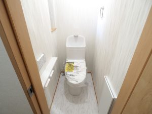 所沢市内戸建て住宅のトイレ、白いトイレとトイレットペーパーホルダーが写っています。